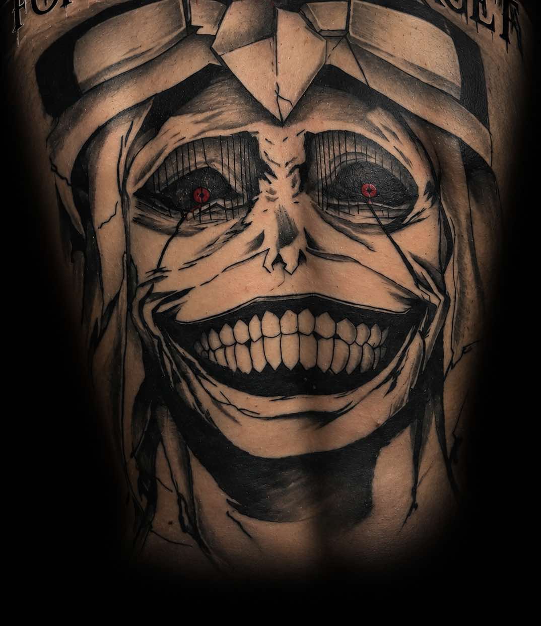 Steve’s large illustrated face tattoo with red eyes